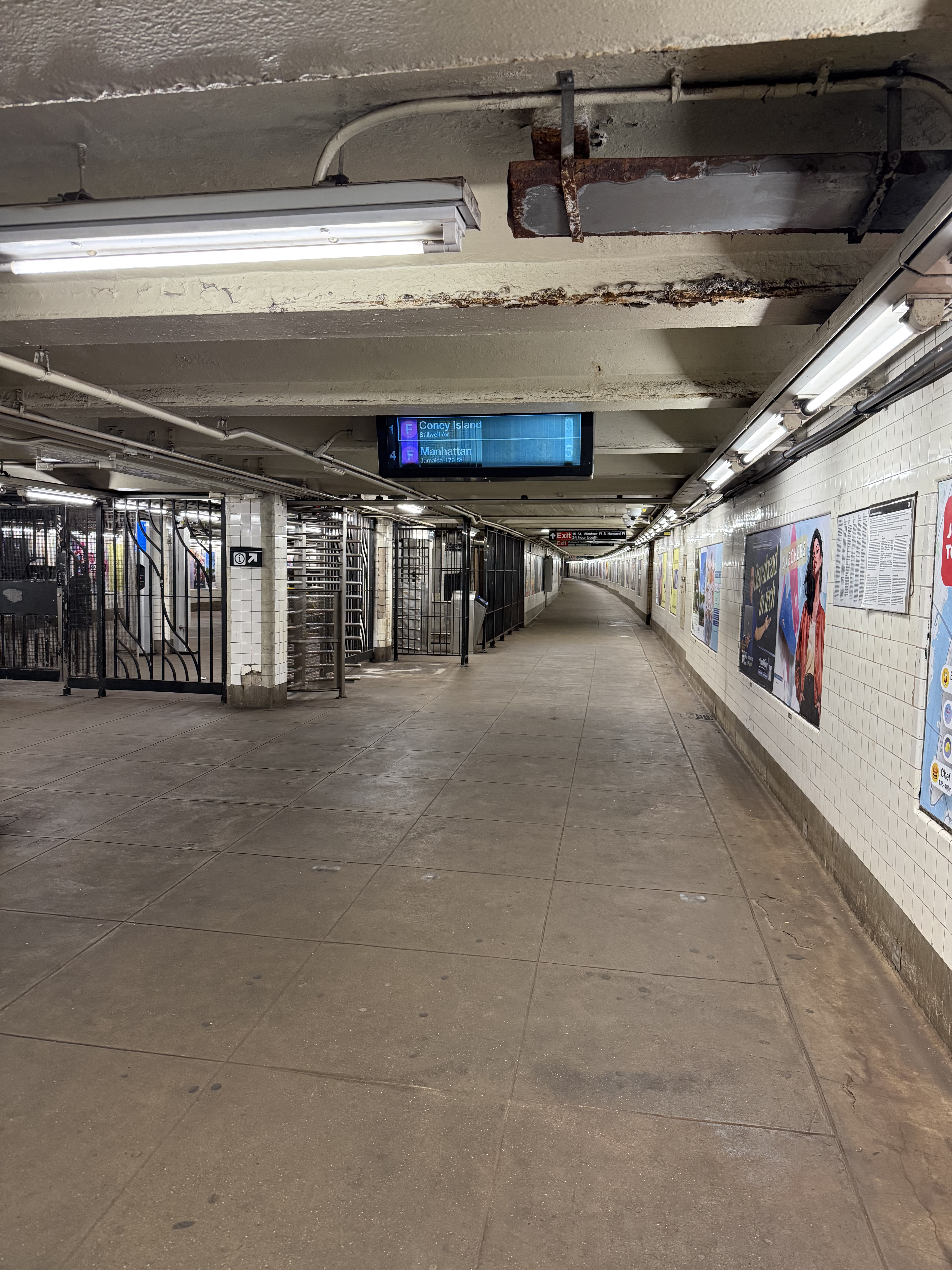 An empty subway station with a very long curved corridor
