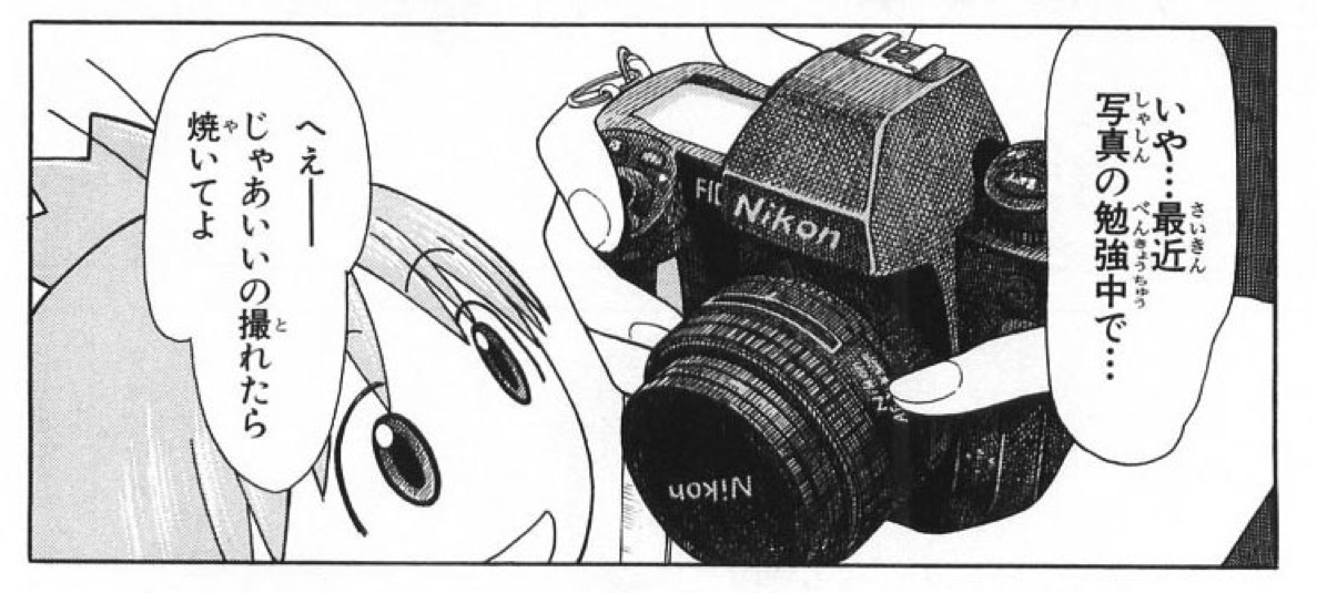 Torako holds her camera and Yotsuba takes a closer look