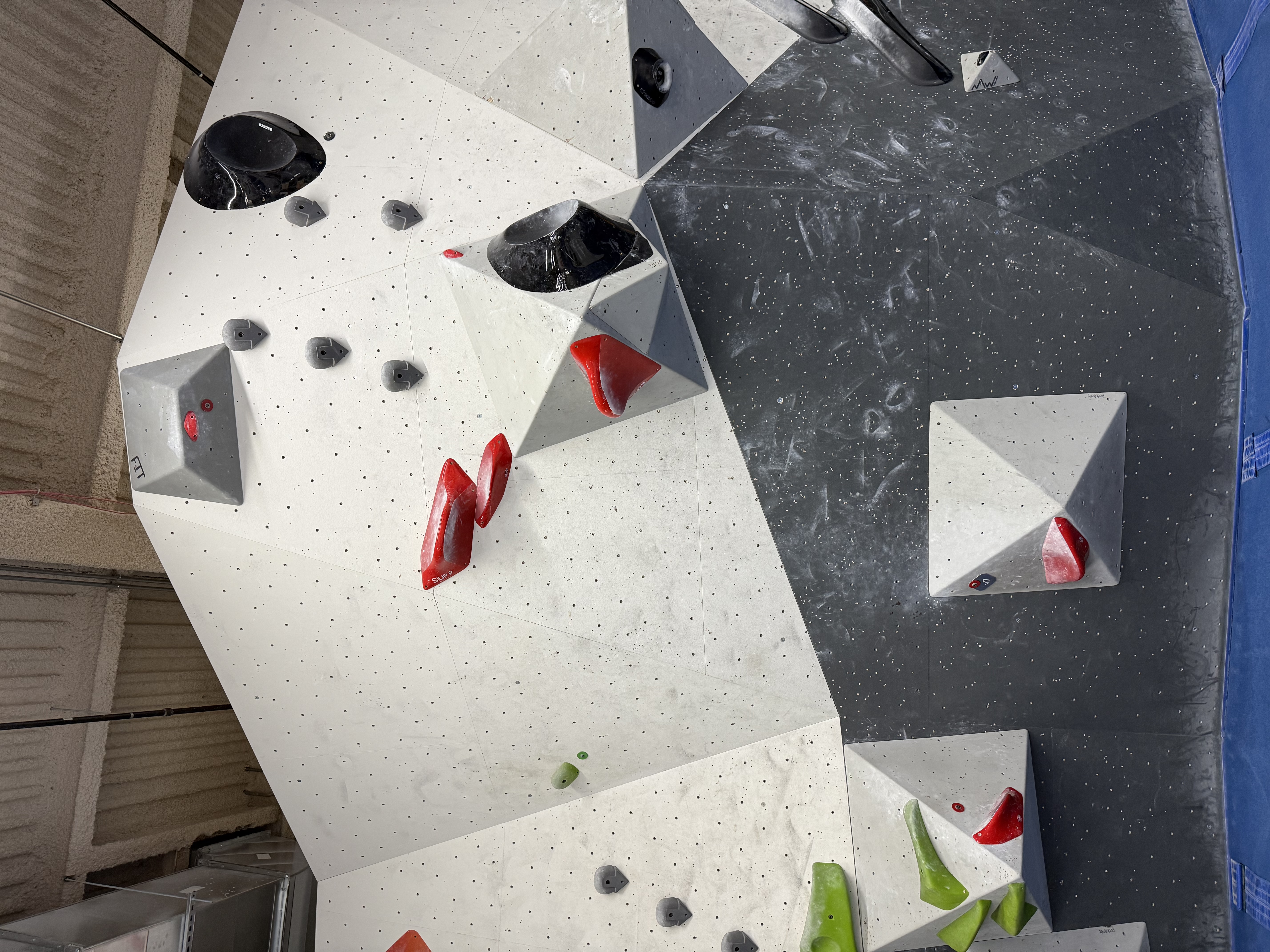 Red V7 with a double start in the corner between two volumes. Both start holds are like platforms. The next hold is a narrow pincher with a wide platform (so, easy to grab) connected to a volume sticking far out from the wall on the right (so you have to jump to it), then two more slightly smaller of the same that are on the wall to the left of the volume. There's a pretty good crimp on the far side of the upper volume, and the top finishes with an upside-down hold directly above the hold you jump to.