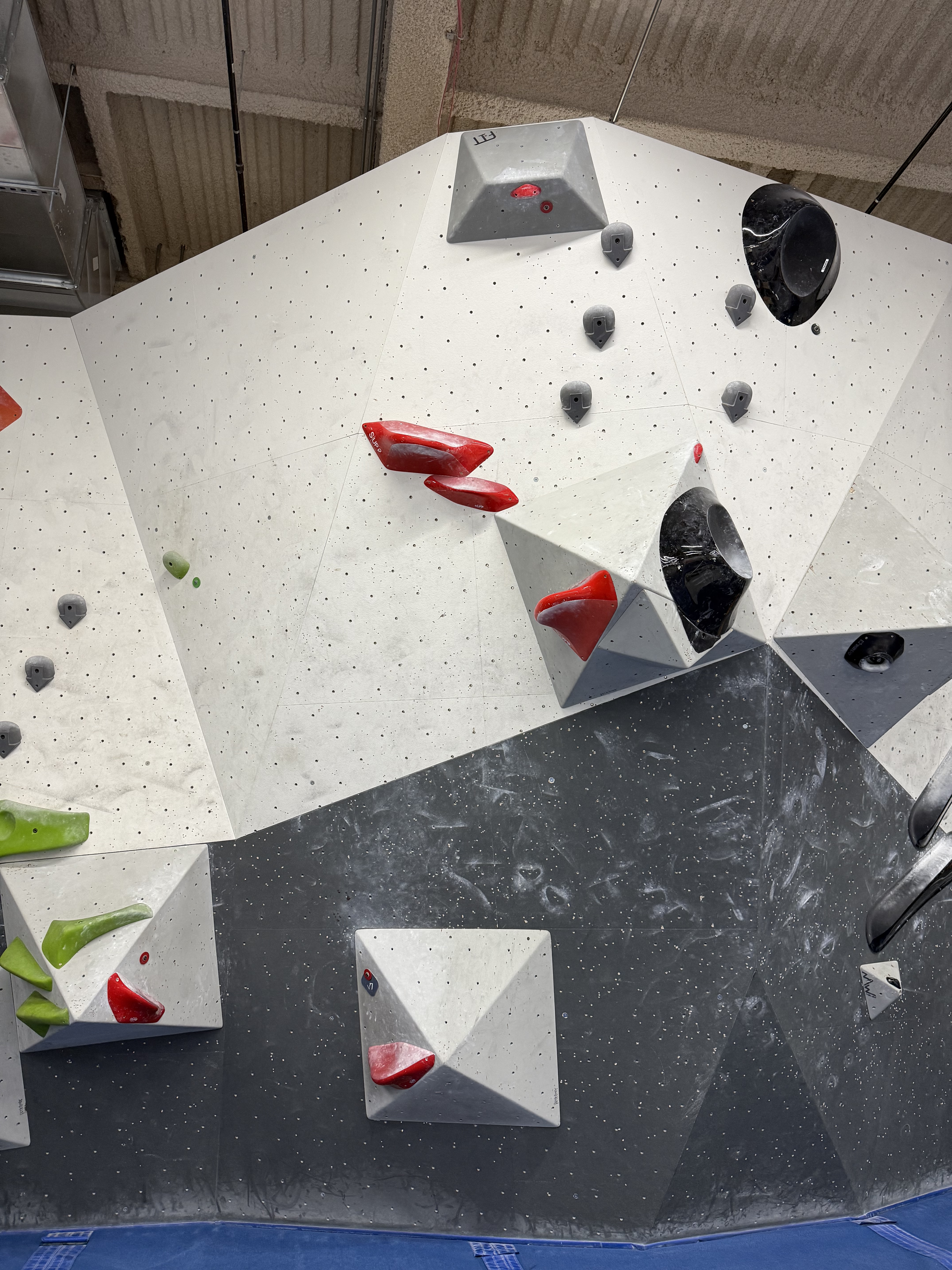 Red V7 with a double start in the corner between two volumes. Both start holds are like platforms. The next hold is a narrow pincher with a wide platform (so, easy to grab) connected to a volume sticking far out from the wall on the right (so you have to jump to it), then two more slightly smaller of the same that are on the wall to the left of the volume. There's a pretty good crimp on the far side of the upper volume, and the top finishes with an upside-down hold directly above the hold you jump to.