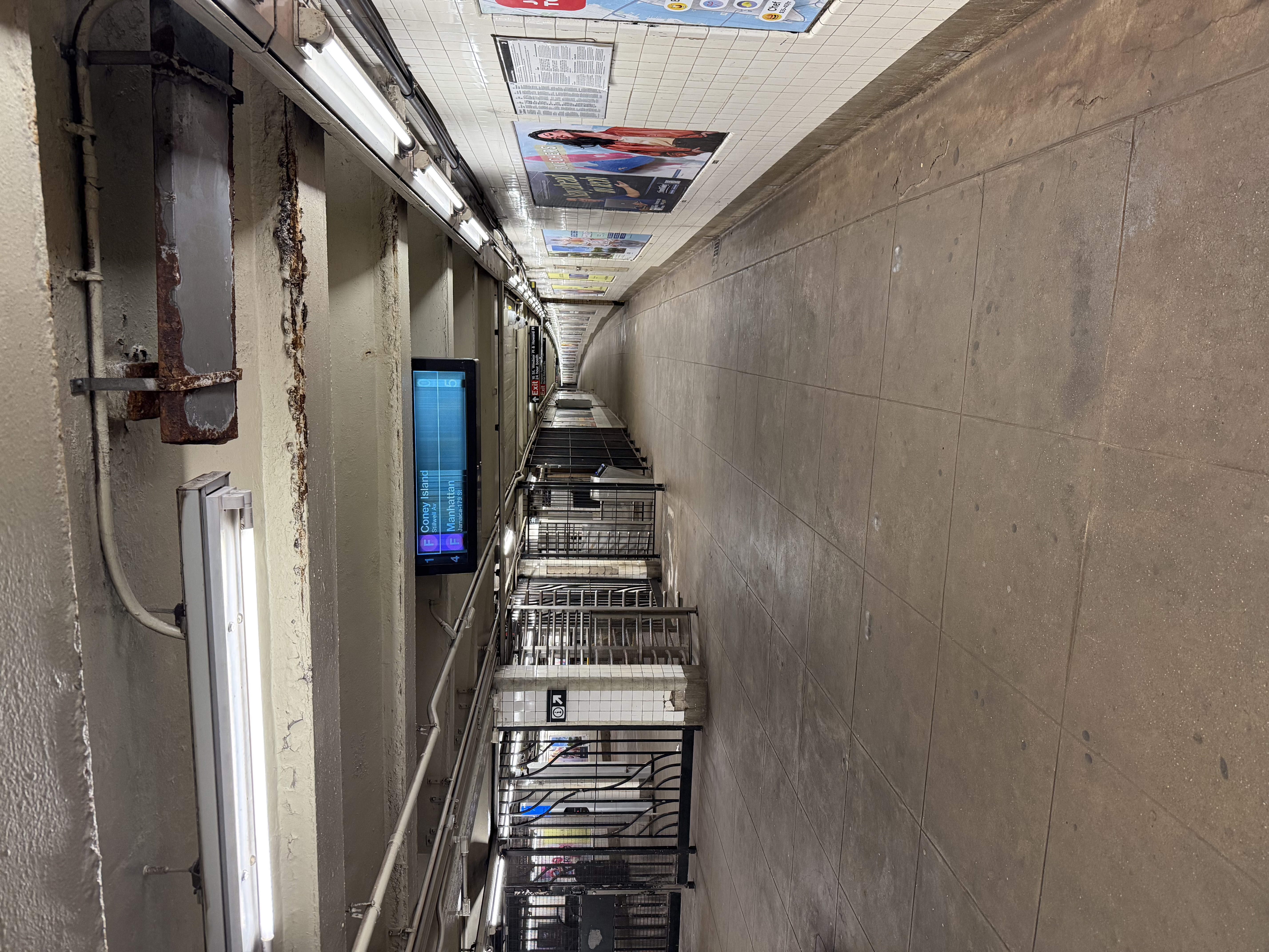 An empty subway station with a very long curved corridor