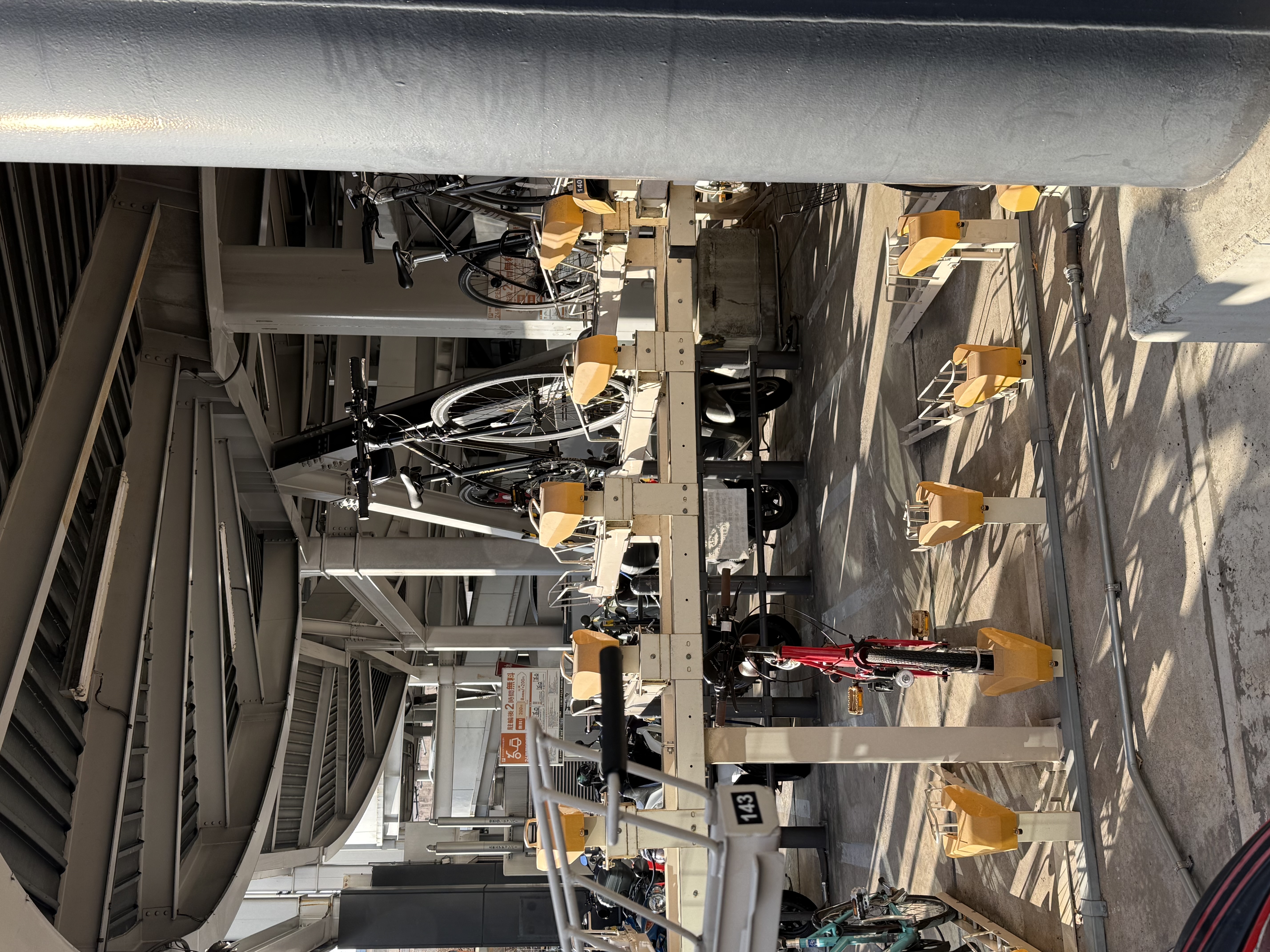 A double-decker bike rack under a pedestrian overpass
