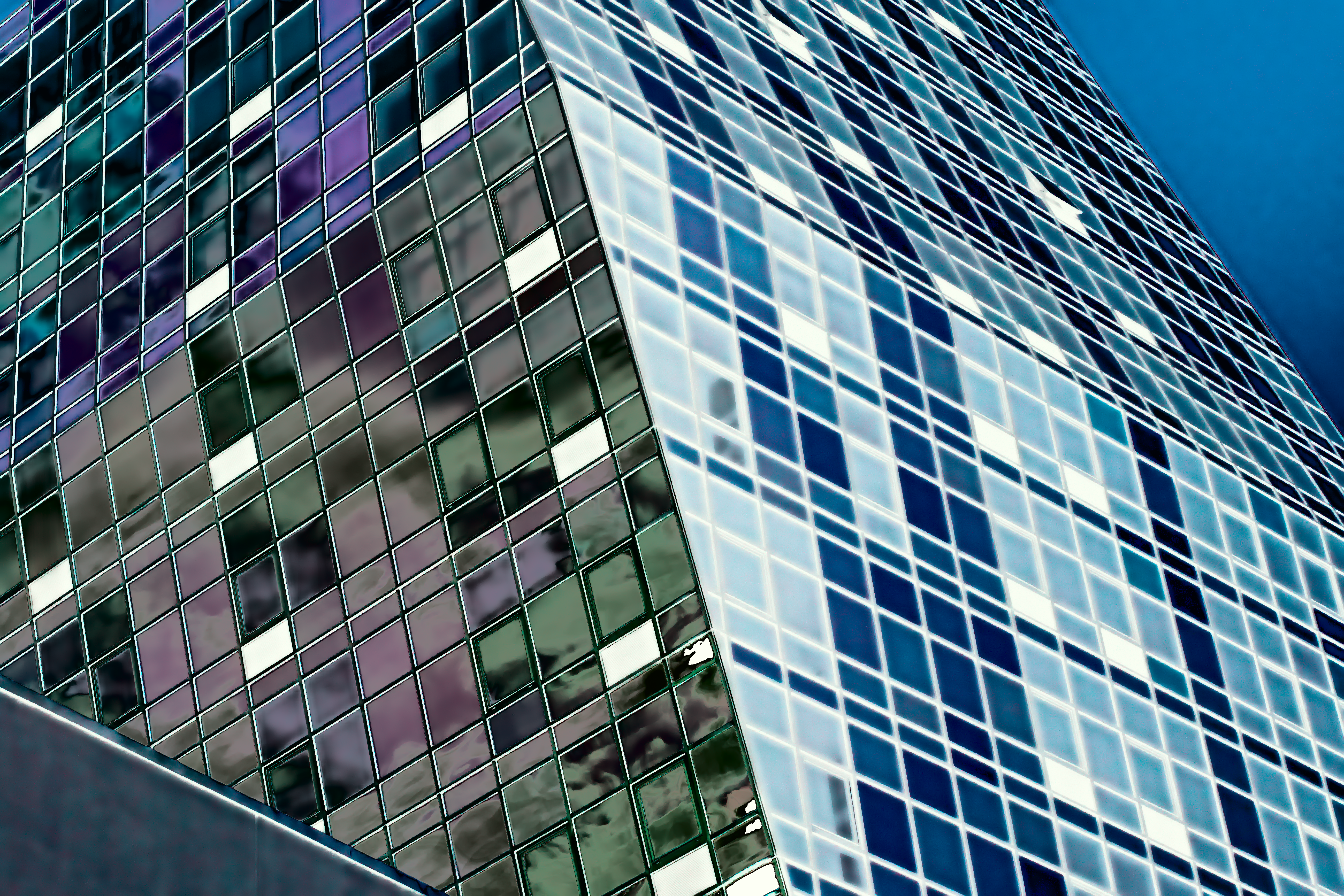 an obelisk-shaped building with square windows is viewed at an impossible angle, the sky and a concrete railing cutting similar triangles in its silhouette. the windows themselves are also impossibly-colored, looking like a film negative in parts, and almost-normal in others.