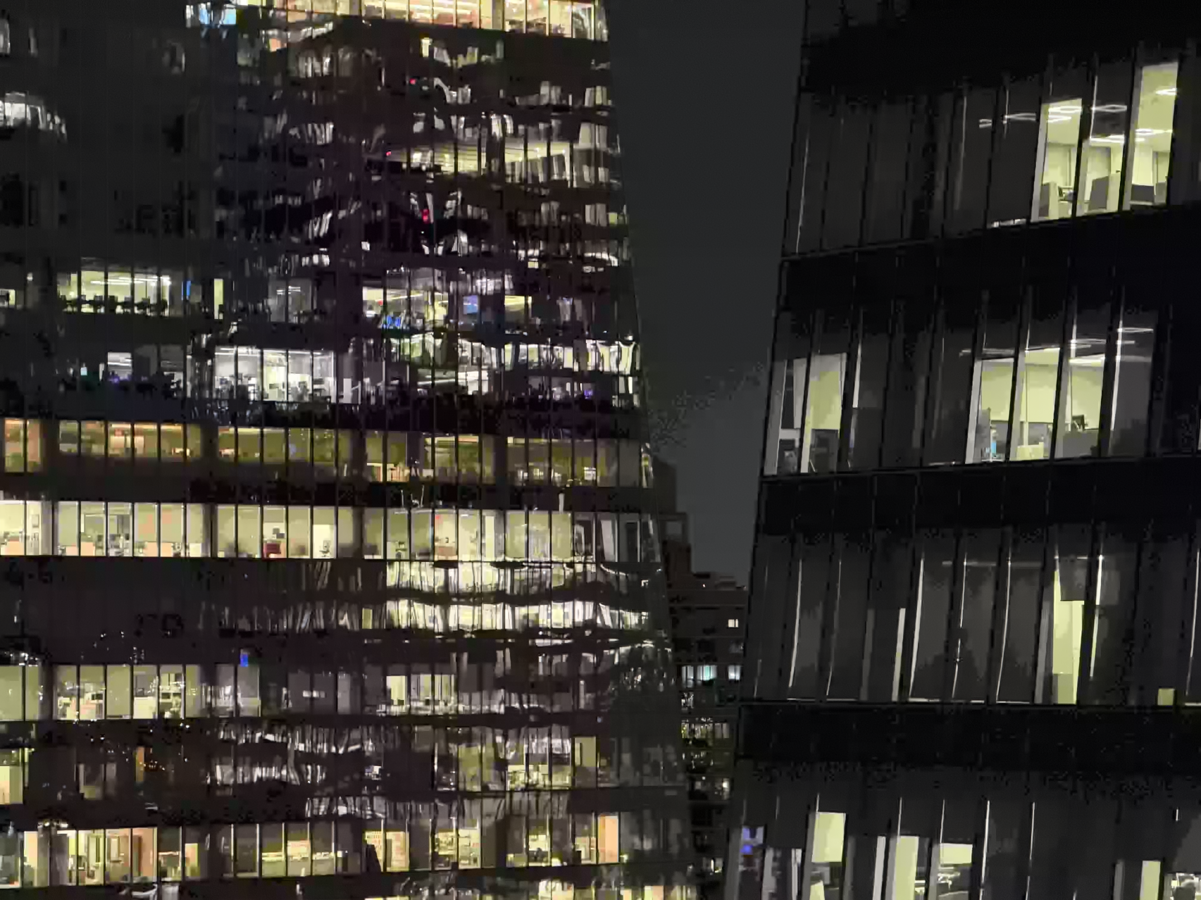 office buildings Sickly yellow warped windowpanes line flanking office buildings, themselves banded against a banding black night sky