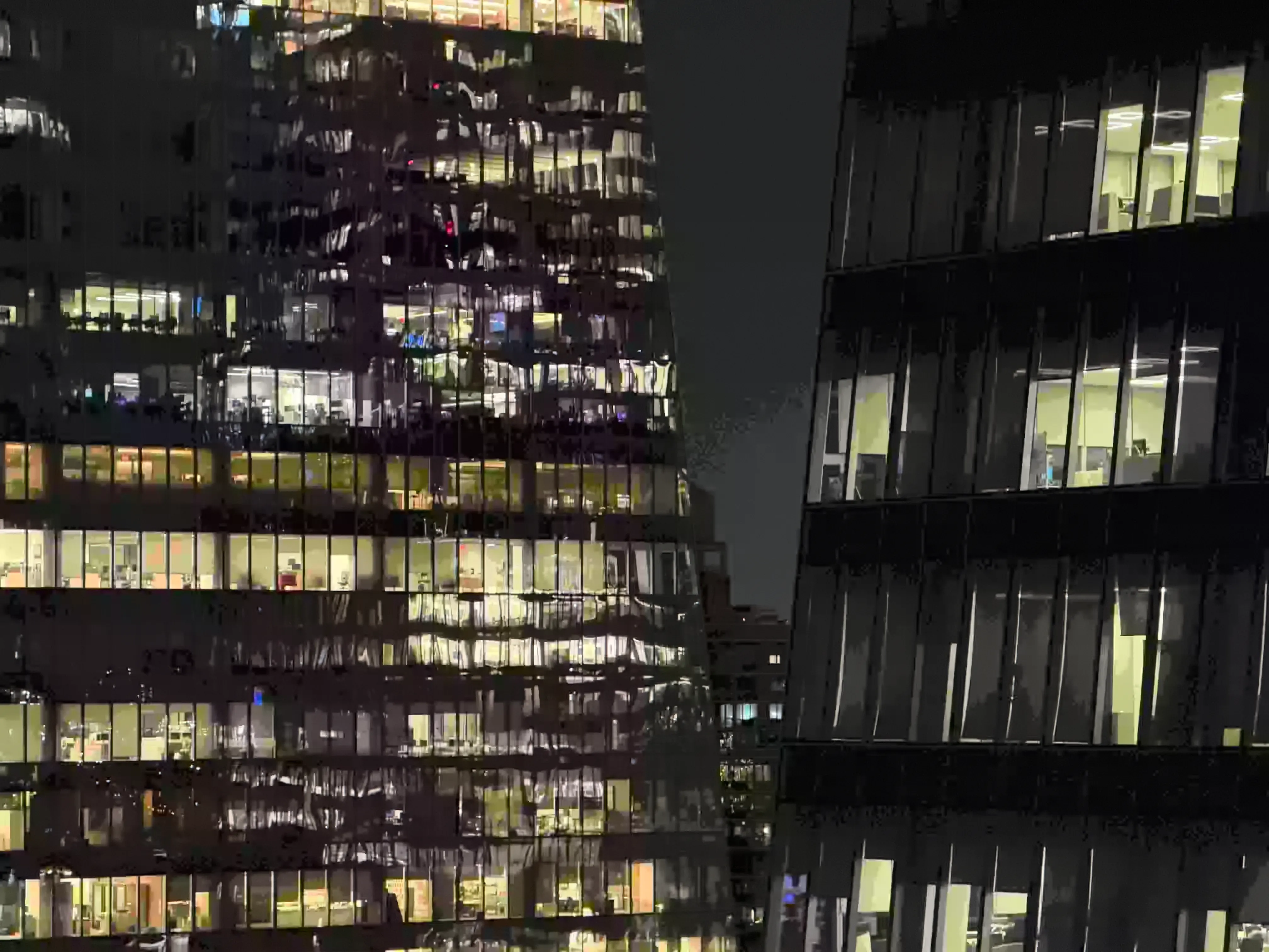 Sickly yellow warped windowpanes line flanking office buildings, themselves banded against a banding black night sky