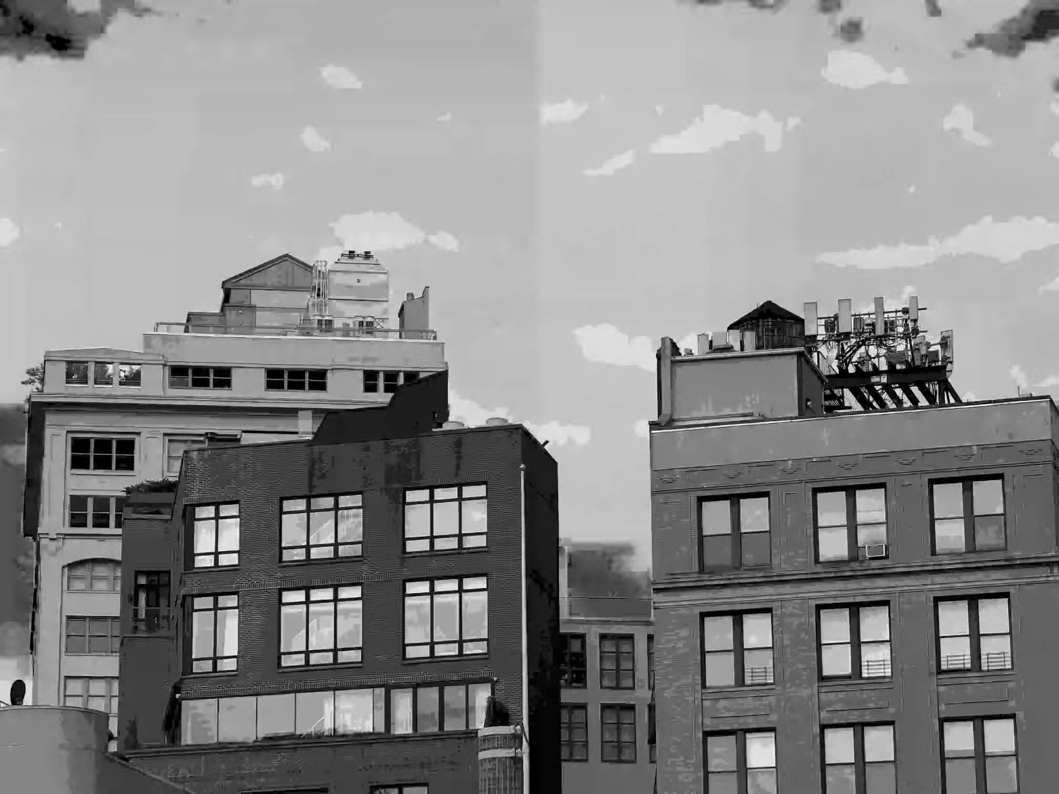 A slight crack in the sky separates poster-shaded monochrome apartment buildings