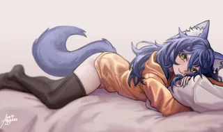 PolyWolf lying on her side on a bed